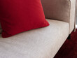 © Miquel Llonch/Stocksy - Red pillow on gray modern couch