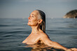 © Alba Vitta/Stocksy - Active mature woman bathing in the sea in the morning