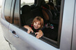 © Irina Polonina/Stocksy - A little girl sitting in a car.