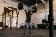 © Manu Padilla/Stocksy - Determined Islamic sportswoman with barbell exercising in gym