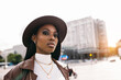 © VICTOR TORRES/Stocksy - Serious black woman in leather coat and hat