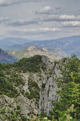 Sticker - Vertical shot of a mountainous landscape on a cloudy sky backgroun