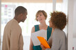 © KOTO - Colleagues talking and smiling in office, holding documents