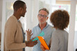 © KOTO - Colleagues talking and smiling in office, holding documents