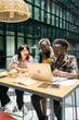 © Luis Velasco/Stocksy - People Sitting Around The Deskt At Work In The Office.