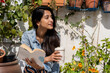 © Alba Vitta/Stocksy - Happy woman in garden relaxing and reading a book