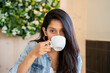 © Alba Vitta/Stocksy - Portrait of young woman drinking coffe looking at camera