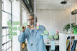 © Mihajlo Ckovric/Stocksy - Man writing notes on a stickers on a glass wall