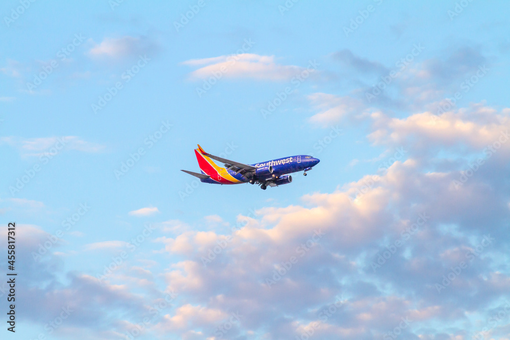 Santa Ana, CA, USA – August 11, 2021: Southwest Airlines airplane flying over the sky of Santa Ana, California, for landing at John Wayne Airport in Orange County.