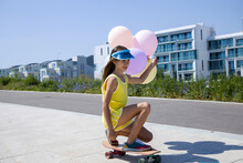 Girls With A Balloons On Skateboard