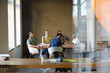 © KOTO - Creative business people working at tables in sunny office