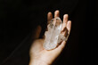 © Eliza Alves/Stocksy - Hand holding a crystal