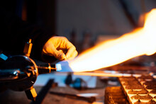 Unrecognizable Glassblower Working With Torch Flame And Glass Tube