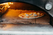 © Melissa Milis Photography/Stocksy - Pizza oven with pizza margherita
