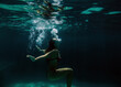 © Lucas Ottone/Stocksy - Woman floating underwater