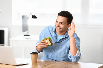 Sticker - Young man with tasty sandwich in office