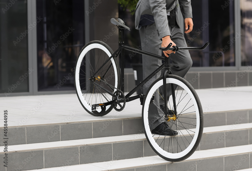 Businessman with bicycle going downstairs