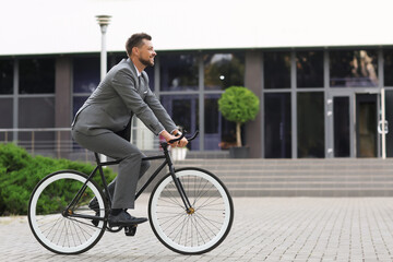 Poster - Businessman going to work by bicycle on city street