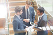 © KOTO - Businessmen with digital tablet and coffee talking on stairs