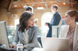 © KOTO - Businesswomen talking and working at laptop in office