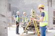 © KOTO - Engineer with clipboard using theodolite at construction site