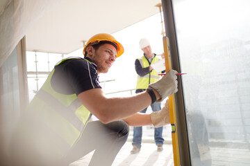 Wall Mural - Construction worker measuring window at construction site