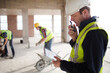© KOTO - Foreman with digital tablet using walkie-talkie at construction site