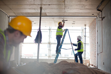 Wall Mural - Construction worker on ladder at construction site