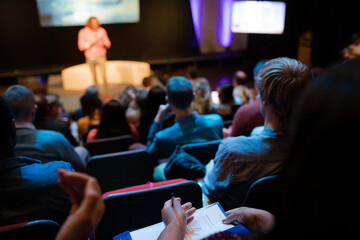 Audience watching male speaker on stage