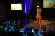 © KOTO - Audience watching male speaker with virtual reality simulator glasses on stage