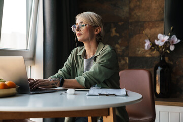 Wall Mural - Middle aged blonde woman with short hair studying