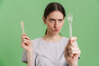 © Drobot Dean - Young brunette woman frown while showing disposable forks