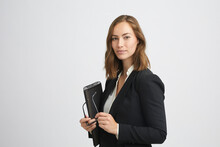 Portrait Of A Confident And Professional Business Woman With A Clipboard And Glasses In Her Hand Looking Elegantly In Camera Isolated On White Background