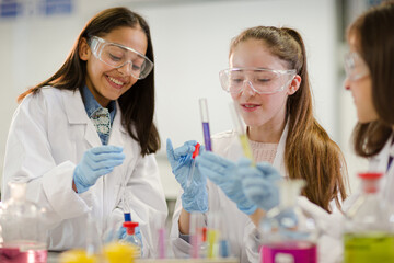 Wall Mural - girl students conducting scientific experiment in laboratory classroom