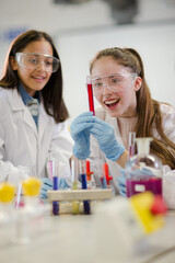 Wall Mural - girl students conducting scientific experiment in laboratory classroom