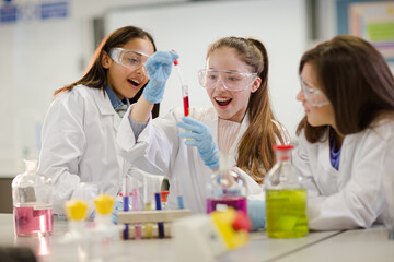 Wall Mural - girl students conducting scientific experiment in laboratory classroom