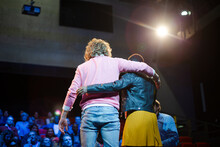 Speakers Hugging On Stage For Audience At Conference