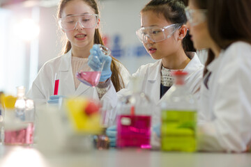 Wall Mural - girl students conducting scientific experiment in laboratory classroom