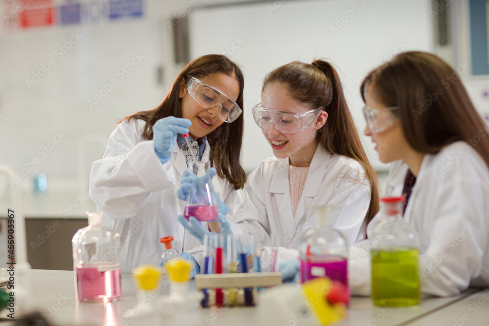 Girl students conducting scientific experiment in laboratory classroom ...
