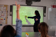 Female science teacher teaching DNA lesson at projection screen