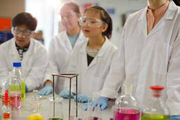 Wall Mural - female teacher and students watching scientific experiment chemical reaction in laboratory classroom