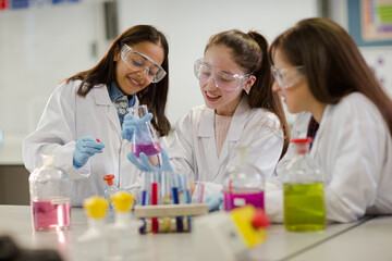 Wall Mural - girl students conducting scientific experiment in laboratory classroom