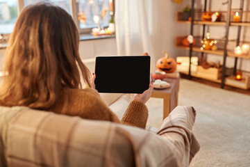 Wall Mural - halloween, holidays and leisure concept - young woman with tablet pc computer at home