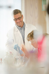 Wall Mural - male teacher and boy students conducting scientific experiment in laboratory classroom