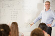 © KOTO - Male teacher leading lesson at whiteboard in classroom
