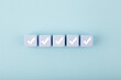 Five checkmarks on white cubes against bright pastel blue background with copy space. Concept of questionary, checklist, to do list, planning, business or verification. Creative minimal composition 