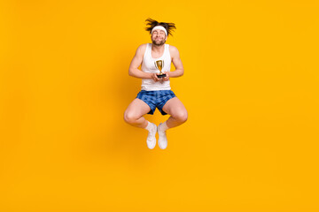 Poster - Full length body size view of attractive cheerful dreamy guy jumping getting cup isolated over bright yellow color background