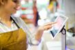 © KOTO - Female cashier using touch screen cash register in grocery store