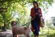 © KOTO - Pregnant woman walking dog in park