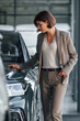 © standret - Woman is indoors near brand new automobile indoors